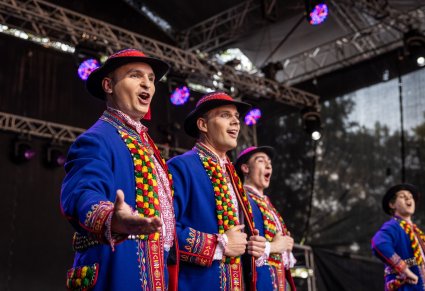 Zbliżenie na Artystów Baletu w kostiumach podegrodzkich śpiewających i wykonujących choreografię taneczną