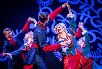 Zbliżenie na pary Artystów w kostiumach kujawskich z zespołu "Mazowsze" podczas wykonywania choreografii tanecznej na scenie