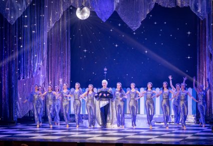 Na scenie Artystki odgrywające role gwiazd a na środku postać księżyca w charakterystycznej białej peruce