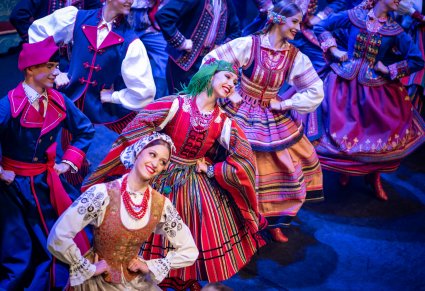 Artyści w kostiumach ludowych podczas wykonywania choreografii tanecznej na scenie