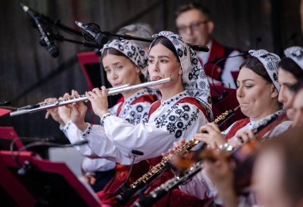 Zbliżenie na Artystki Orkiestry w kostiumach wilanowskich w trakcie grania na instrumentach dętych