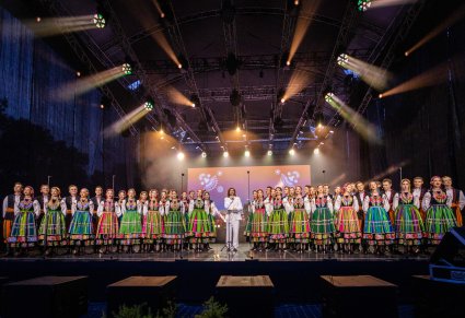 Na środku sceny wokalista zespołu Pectus a po jego bokach Artyści Chóru w kostiumach łowickich