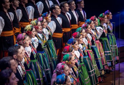 Widok boczny na Artystów Chóru w kostiumach łowickich podczas śpiewu