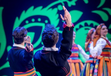 Zbliżenie na tancerza w stroju łowickim w figurze tanecznej