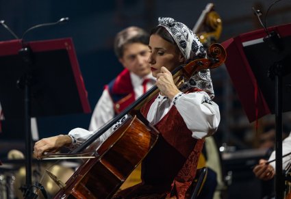 Zbliżenie na Artystkę Orkiestry w trakcie gry na instrumencie smyczkowym
