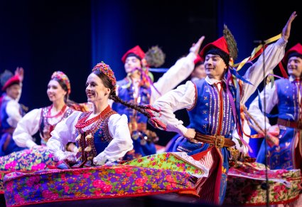 Zbliżenie na Artystów Baletu w kostiumach krakowskich w trakcie wykonywania choreografii tanecznej