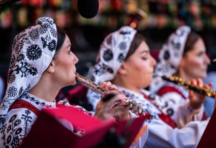 Zbliżenie na muzyków orkiestry, grających na instrumentach dętych