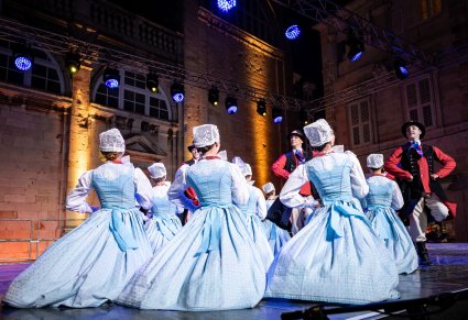 Grupa Artystów w kostiumach szamotulskich na scenie w trakcie wykonywania choreografii tanecznej