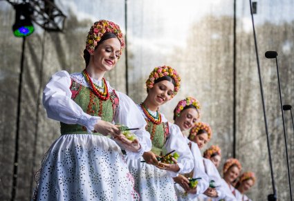Uśmiechnięte Artystki w kostiumach lubuskich w rękach trzymające winogrono
