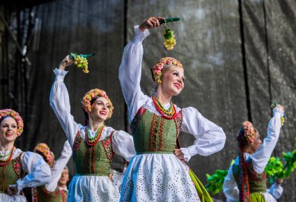 Uśmiechnięte Artystki w kostiumach lubuskich w rękach trzymające winogrono