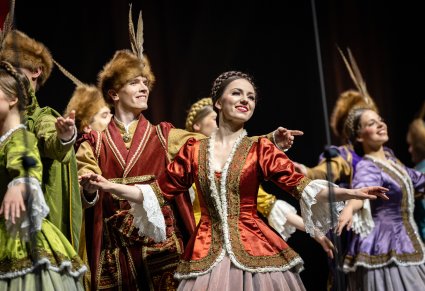 Zbliżenie na grupę Artystów w kontuszach podczas wykonywania choreografii tanecznej na scenie