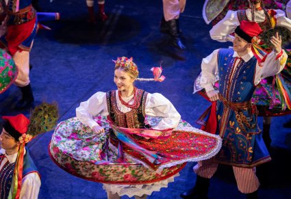 Zbliżenie na Artystkę w kostiumie krakowskim podczas wykonywania choreografii tanecznej