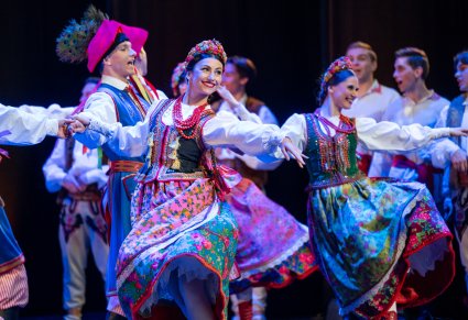 Zbliżenie na pary Artystów w kostiumach krakowskich w trakcie wykonywania choreografii tanecznej