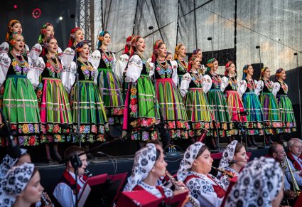 Widok na chór w kostiumach łowickich, poniżej część orkiestry w kostiumach wilanowskich