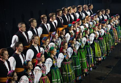 Zbliżenie na Artystów Chóru w kostiumach łowickich w trakcie śpiewu