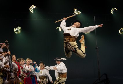 Na pierwszym planie Skaczący Artysta Baletu w kostiumie podhalańskim, w tle część Artystów również w kostiumach podhalańskich