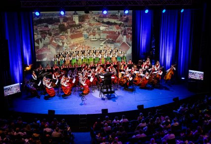 Widok z góry na scenę z Artystami z widocznymi paroma rzędami publiczności