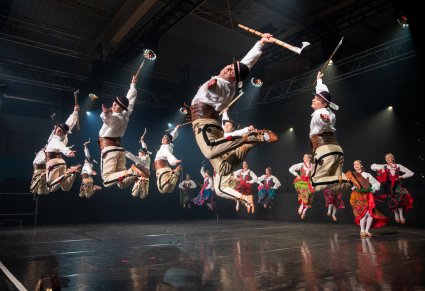 Na scenie Artyści w kostiumach podhalańskich w trakcie wykonywania spektakularnych figur tanecznych