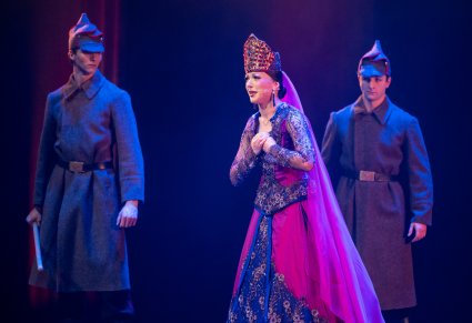 Na pierwszym planie postać Królowej a za nią dwóch Żołdaków