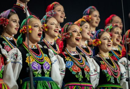 Zbliżenie na Artystki Chóru w kostiumach łowickich w trakcie śpiewu