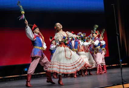 Na scenie grupa Artystów w kostiumach inspirowanych, wykonująca choreografię taneczną