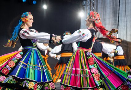 Zbliżenie na parę Artystek w kostiumach łowickich podczas wykonywania choreografii tanecznej