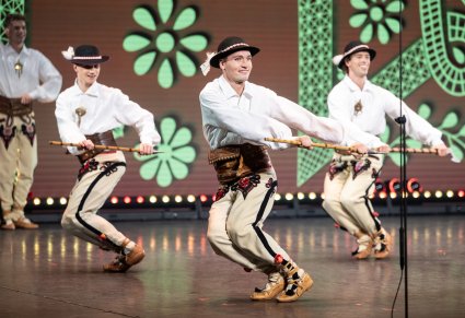 Artyści w kostiumach podhalańskich podczas wykonywania choreografii tanecznej z ciupagami