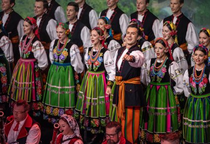 Na pierwszym planie Solista a za nim część Artystów chóru w kostiumach łowickich na dole zdjęcia część osób z orkiestry