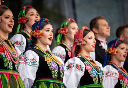 Zbliżenie na Artystów z chóru w kostiumach łowickich