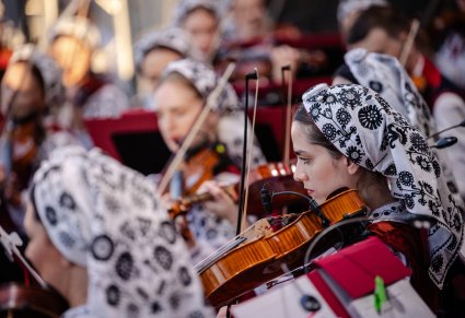 Zbliżenie na Muzyczki w kostiumach wilanowskich w trakcie grania na instrumentach smyczkowych