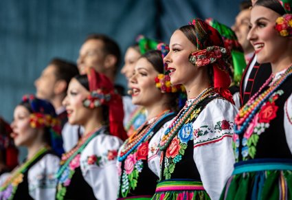 Zbliżenie na śpiewających Artystów w kostiumach łowickich