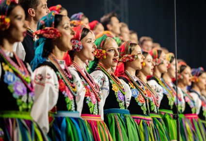 Zbliżenie na Artystki Chóru w kostiumach łowickich w trakcie śpiewu