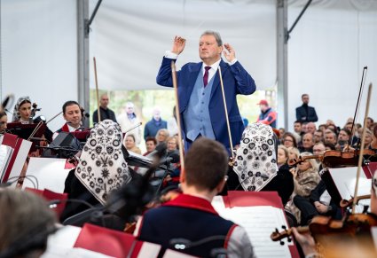 Widok z tyłu orkiestry na dyrygującego Dyrektora zespołu