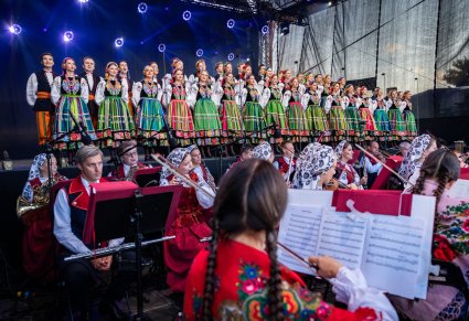 Widok na chór w kostiumach łowickich, poniżej orkiestra w kostiumach wilanowskich i podhalańskich