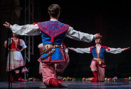 Artyści w choreografii tanecznej na scenie w kostiumach stylizowanych na kostium krakowski
