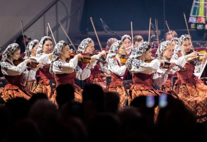 Zbliżenie na grupę Artystek Orkiestry w kostiumach wilanowskich w trakcie gry na instrumentach smyczkowych