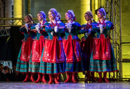 Artystki w kostiumach kujawskich na scenie wykonujące choreografię taneczną