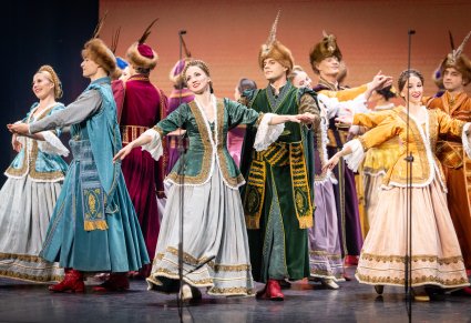 Zbliżenie na Artystów Baletu w kontuszach w trakcie wykonywania choreografii tanecznej