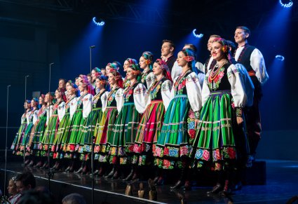 Na scenie Artyści chóru w kostiumach łowickich