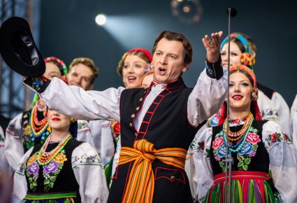 Artysta w kostiumie łowickim podczas wykonywania "Furmana", w tle chór także w kostiumach łowickich