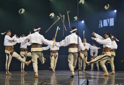 Grupa Artystów w kostiumach podhalańskich w trakcie wykonywania imponującej choreografii tanecznej