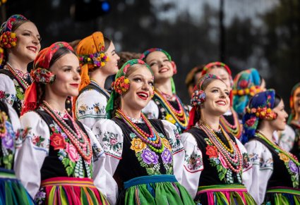 Zbliżenie na Artystki Chóru w kostiumach łowickich podczas śpiewu na scenie