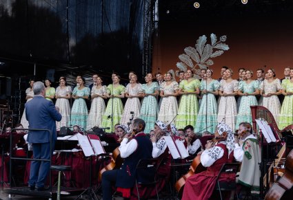 Widok na chór w kostiumach stylowych z końca XIX wieku wraz z Orkiestrą w kostiumach wilanowskich i Dyrygentem zwróconym w ich stronę