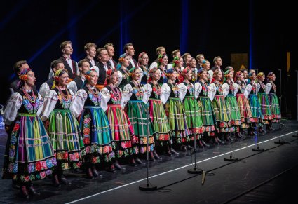 Na scenie Artyści chóru w kostiumach łowickich podczas śpiewu