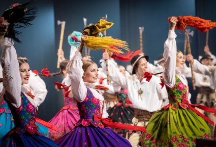 Zbliżenie na Artystów w kostiumach podhalańskich w trakcie wykonywania choreografii tanecznej
