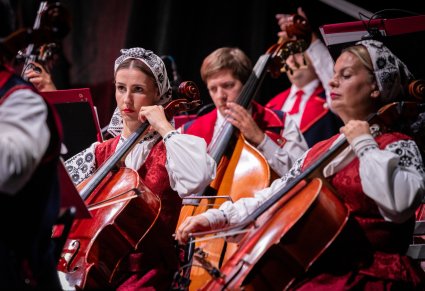 Zbliżenie na muzyków orkiestry w kostiumach wilanowskich, grajacych na instrumentach smyczkowych