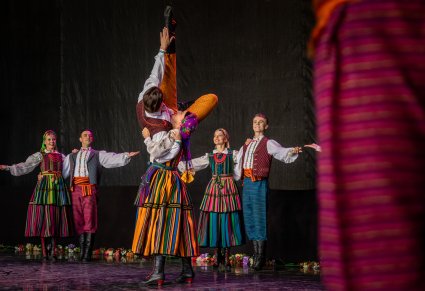 Artyści na scenie w kostiumach opoczyńskich w trakcie wykonywania choreografii tanecznej
