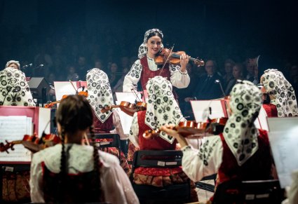 Na pierwszym planie skrzypaczka i reszta część orkiestry w kostiumach wilanowskich