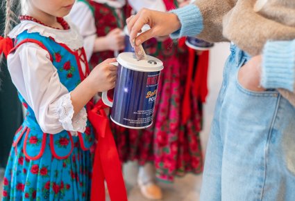 Dziewczynka w kostiumie podhalańskim trzymająca puszkę na datki