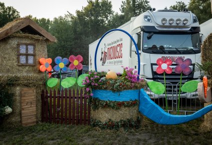 Ozdoby dożynkowe a w tle samochód "Mazowsza"